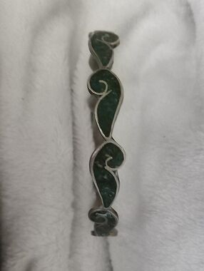 The green material is crushed malachite or turquoise chip inlay. Modernist hinge